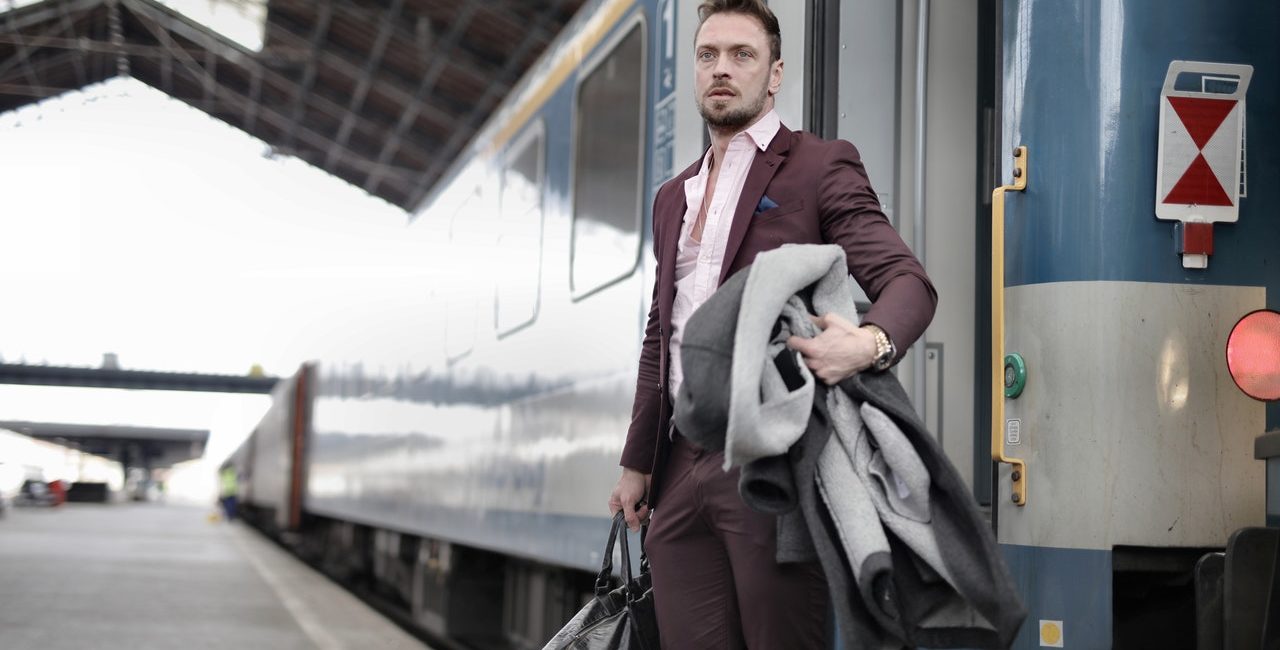 Emigrante davanti a treno espresso ferrovie, articolo di Estrogeni&Partners